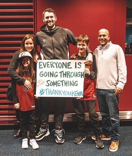 kevin love fun holding a sign saying everyone is going through something, thank you kevin, the slogan for the Kevin Love Fun which champions mental health in young athletes